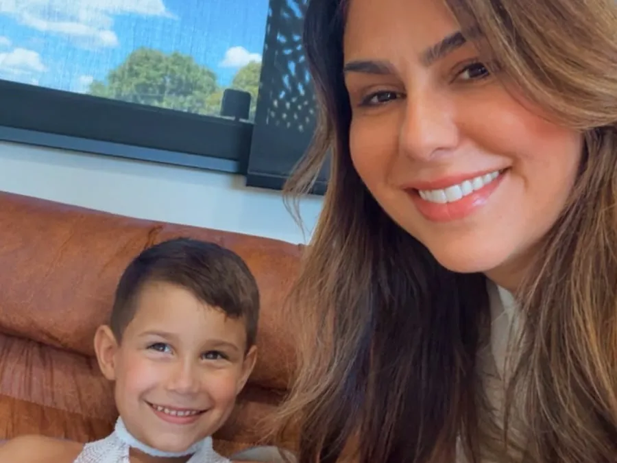 Menino sorrindo ao lado da Larissa, na sala de atendimento em Roraima